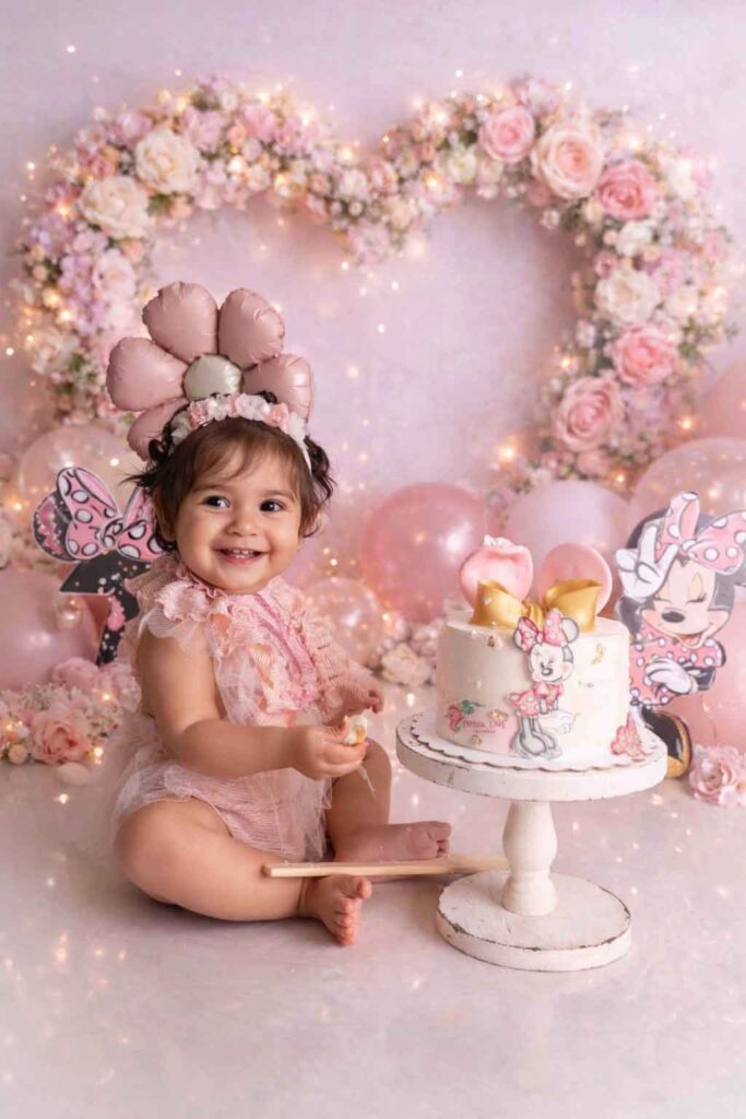 Bebé en sesión smash cake Minnie Mouse Disney con decoración rosa pastel